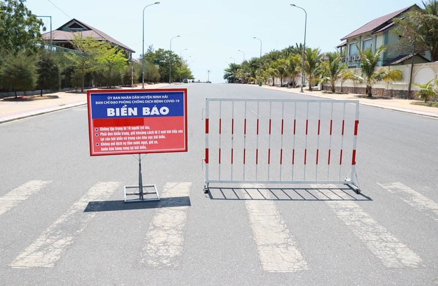 Biển báo phòng chống dịch Covid-19 được dựng ở đường xuống bãi biển Bình Sơn-Ninh Chữ, thành phố Phan Rang-Tháp Chàm. (Ảnh: Nguyễn Thành/TTXVN)