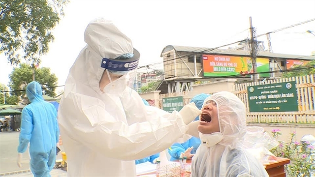 A man receives a screening swab test at Bach Mai Hospital. One more infection connected to the hospital was reported on Thursday morning. 