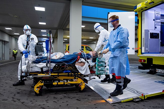 Nhân viên y tế chuyển bệnh nhân nhiễm Covid-19 lên xe cứu thương tới bệnh viện ở Ulm, tây nam nước Đức, ngày 29-3. Ảnh: AFP-TTXVN
