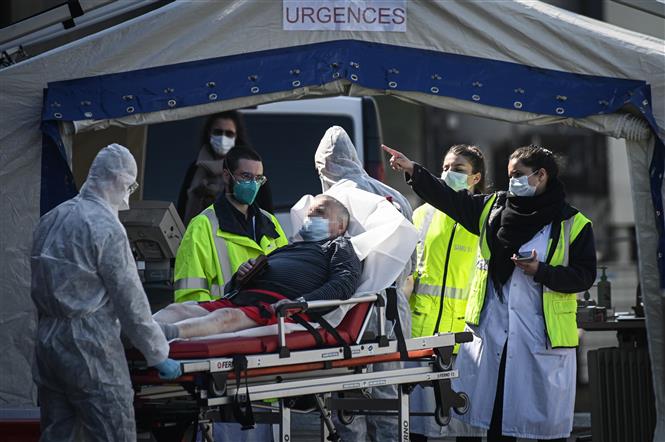 Nhân viên y tế chuyển bệnh nhân nhiễm Covid-19 tới bệnh viện ở ngoại ô Paris, Pháp, ngày 1-4-2020. Ảnh: AFP/TTXVN