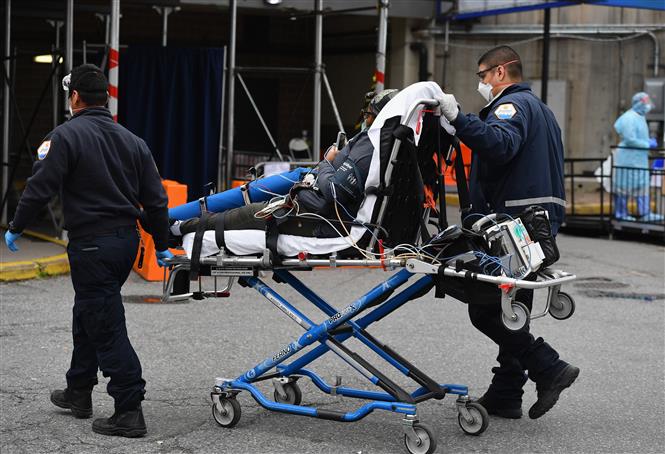 Nhân viên y tế chuyển bệnh nhân nhiễm Covid-19 tới bệnh viện Brooklyn ở New York (Mỹ). Ảnh: AFP/TTXVN