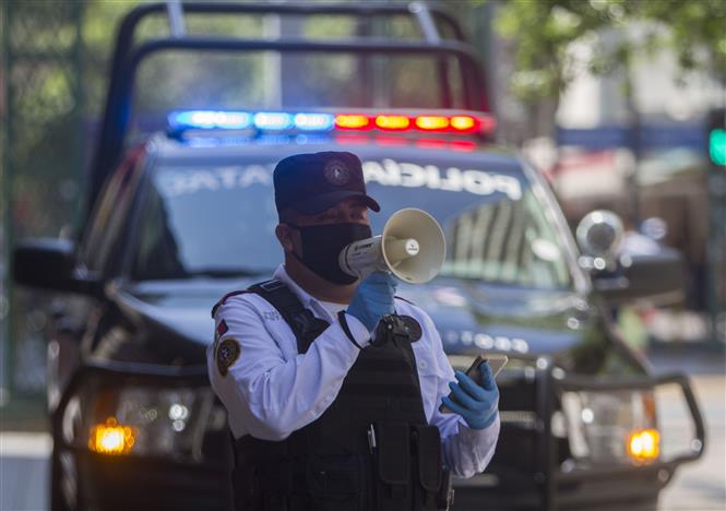 Cảnh sát thông báo người dân hạn chế ra ngoài do dịch Covid-19 tại Monterrey, Mexico ngày 25-3-2020. Ảnh: THX/TTXVN