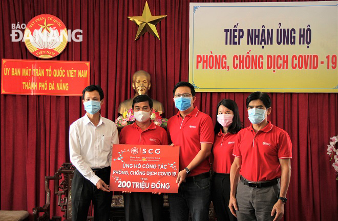 Phó Chủ tịch Ủy ban MTTQ Việt Nam thành phố Lê Văn Minh tiếp nhận ủng hộ từ Công ty TNHH Vật liệu xây dựng Xi măng SCG Việt Nam. Ảnh: L.P