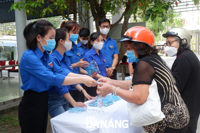 Các đoàn viên thanh niên Bệnh viện C Đà Nẵng tặng khẩu trang vải miễn phí cho các bệnh nhân cùng người nhà bệnh nhân đến thăm khám tại bệnh viện. Ảnh: M.H