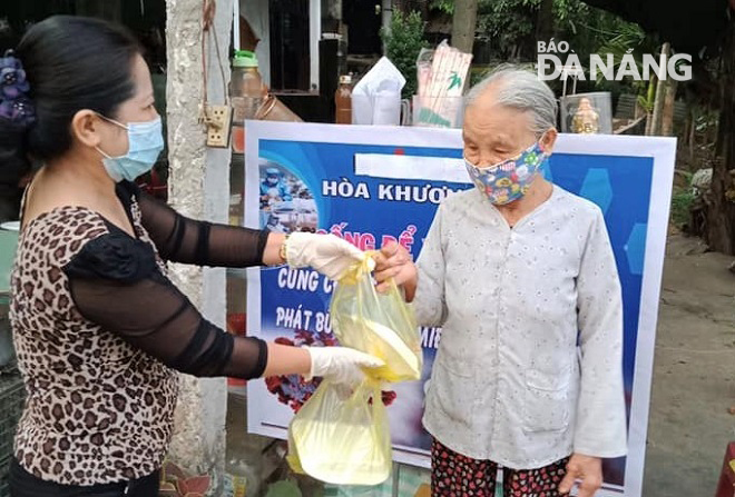 Women in Hoa Khuong Dong Village giving free breakfast meals to villagers, including …