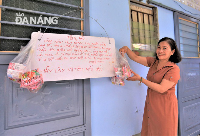 Ms Nguyen Thi Xuan Huong and a notice board outside her boarding house announcing free instant noodles for renters 