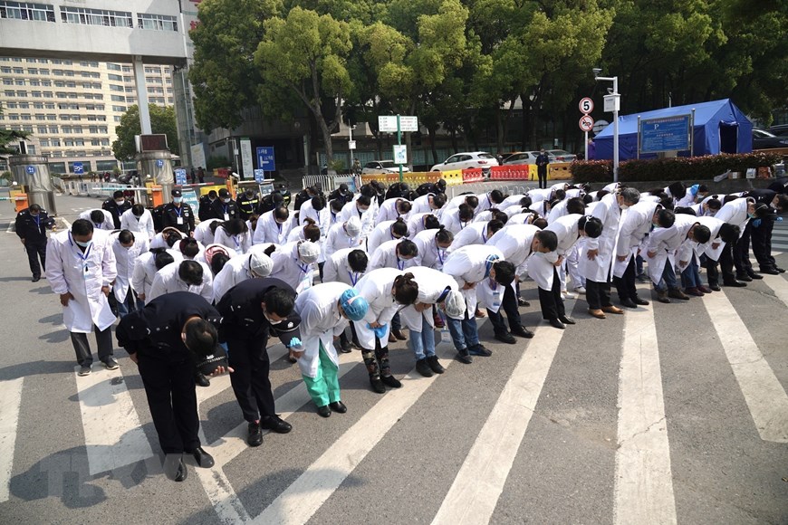 Các y bác sỹ mặc niệm trong lễ quốc tang tưởng nhớ các liệt sỹ và bệnh nhân tử vong vì đại dịch COVID-19 ở Vũ Hán, tỉnh Hồ Bắc, Trung Quốc ngày 4/4/2020. (Nguồn: THX/TTXVN)