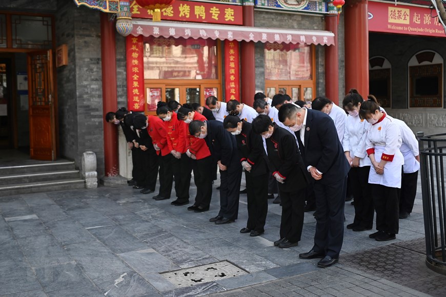 Các nhân viên một nhà hàng mặc niệm trong lễ quốc tang tưởng nhớ các liệt sỹ và bệnh nhân tử vong vì đại dịch COVID-19 ở Bắc Kinh, Trung Quốc ngày 4/4/2020. (Nguồn: AFP/TTXVN)