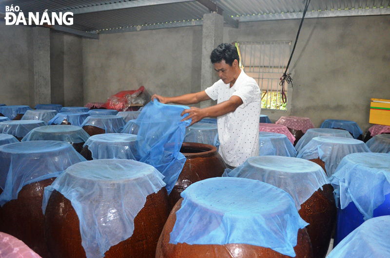 Vats of fish sauce at a production facility in the Nam O Village