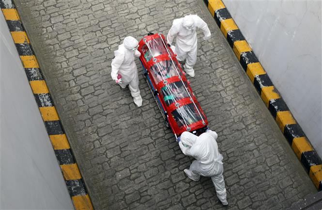 Nhân viên y tế Hàn Quốc vận chuyển người mắc COVID-19 tại Daegu. Ảnh: AFP/TTXVN