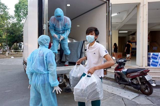 Medical workers deliver meals for people staying at the quarantine area in HCM City National University. More than 78,400 people have completed the compulsory 14-day quarantining period and have returned home.