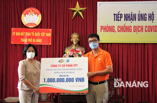 Chairwoman of the municipal Fatherland Front Committee Dang Thi Kim Lien (left) receiving donations from FPT JSC representative