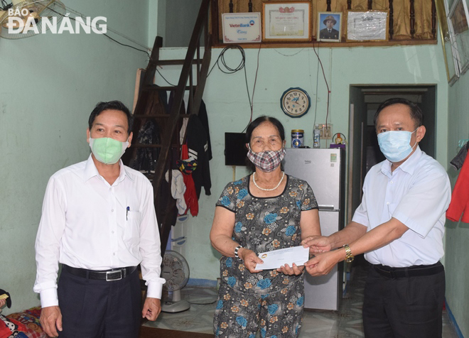 Lãnh đạo UBND và Ủy ban MTTQ Việt Nam quận Sơn Trà trao tiền hỗ trợ cho một gia đình có hoàn cảnh khó khăn và bị ảnh hưởng bời Covid-19 ở phường Thọ Quang, quận Sơn Trà. Ảnh: HOÀNG HIỆP