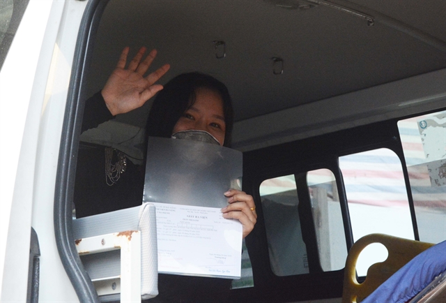 Patient number 122 waves goodbye as she holds up a certificate confirming she has made a full recovery. She was admitted to the Đà Nẵng General Hospital on March 22. During treatment she was tested a further three times and all results came back negative. Now she will self-isolate at home for 14 days. 