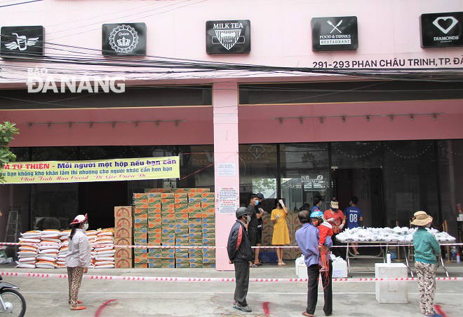 Mọi người xếp hàng nhận cơm tại điểm phát cơm số 291 Phan Châu Trinh (quận Hải Châu). Ảnh: L.P