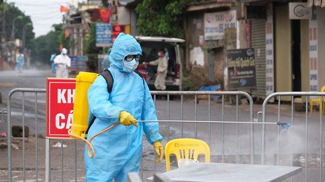 Medical staff spray disinfectant in Ha Loi Village, Me Linh District on Tuesday after a resident tested positive for Covid-19.