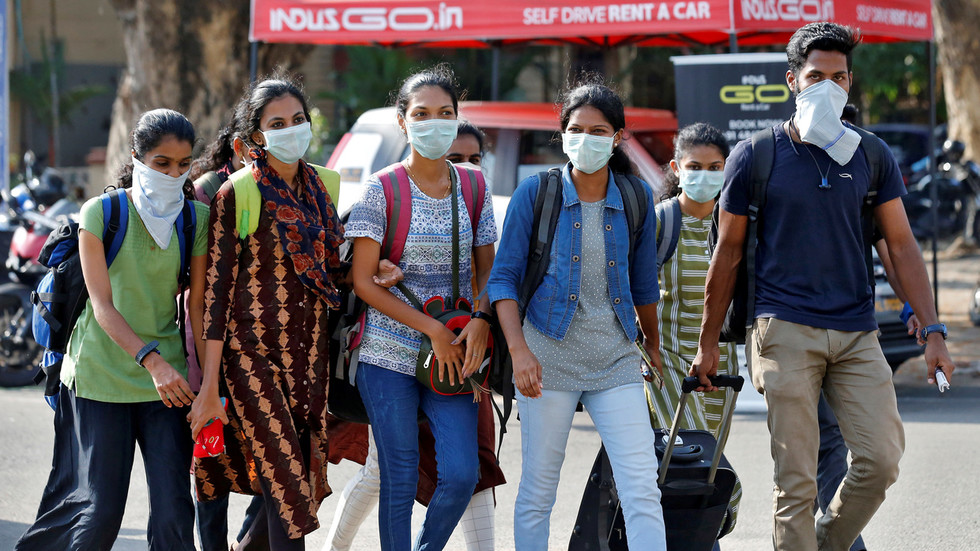 Một nhóm sinh viên Ấn Độ đeo khẩu trang bên ngoài một nhà ga tàu hỏa tại Kochi, Ấn Độ. Ảnh: Reuters 