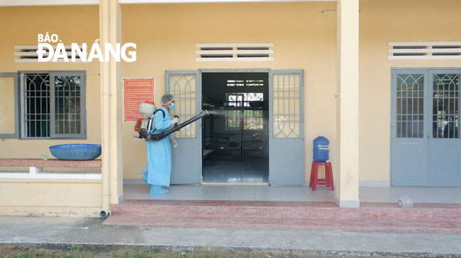 A medical worker is spraying disinfectant at an isolation area in the Dong Nghe Training Centre 