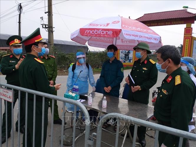  Các lực lượng triển khai nhiệm vụ cách ly y tế tại thôn Hạ Lôi. Ảnh: Nguyễn Cúc/TTXVN