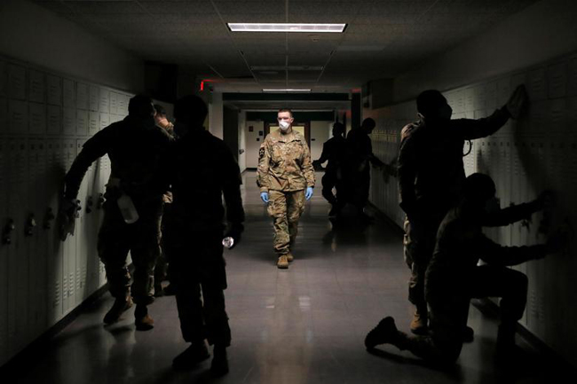 Quân nhân Mỹ khử trùng một trường trung học ở New York. Ảnh: Reuters
