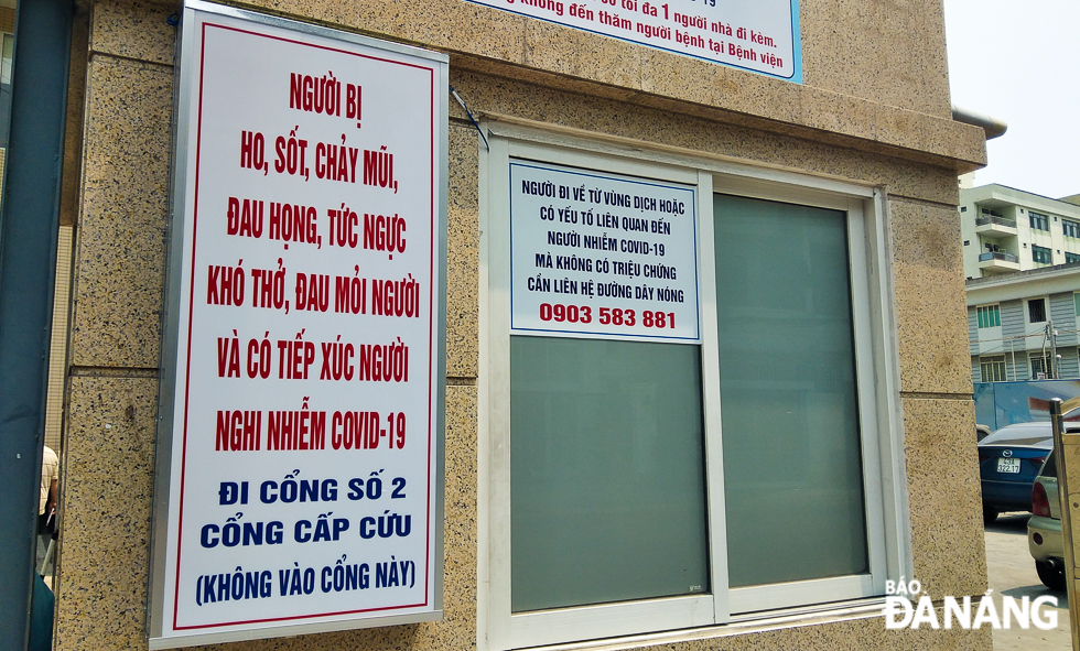 A notice board giving instructions for visitors suspected of having symptoms of coronavirus such as fever, cough, shortness of breath, runny nose, and sore throat.