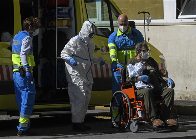 Nhân viên y tế chuyển bệnh nhân nhiễm Covid-19 tới bệnh viện ở Madrid, Tây Ban Nha. Ảnh: AFP/TTXVN