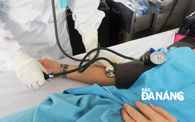  A healthcare worker measuring blood pressure of an infected patient