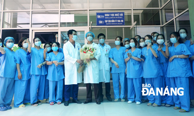 Leader of the Da Nang General Hospital presenting flowers to staff of the Tropical Medicine Ward in recognition for their relentless efforts and great devotion for treating coronavirus infected patients over the past month.