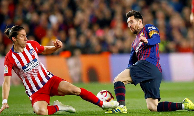 Filipe Luis (trái) nhiều lần phải đá xấu để ngăn cản Messi. Ảnh: EFE.
