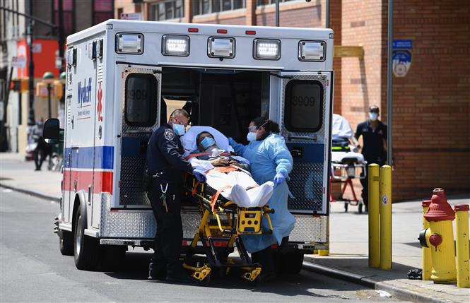 Nhân viên y tế chuyển bệnh nhân mắc COVID-19 từ xe cứu thương vào một bệnh viện ở New York, Mỹ ngày 7/4/2020. Ảnh: AFP/TTXVN
