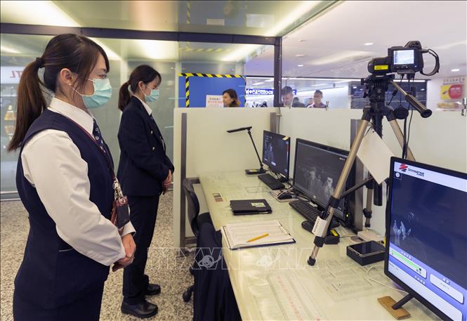 Nhân viên Trung tâm Kiểm soát dịch bệnh Đài Loan, Trung Quốc, sử dụng máy quét để kiểm tra thân nhiệt các hành khách trên chuyến bay từ Vũ Hán, Trung Quốc, tại sân bay quốc tế Đào Viên, ngày 13/1/2020. Ảnh: AFP/TTXVN