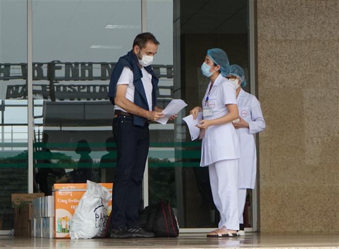 Bác sĩ Bệnh viện Bệnh Nhiệt đới Trung ương cơ sở 2 (Đông Anh, Hà Nội) trao giấy chứng nhận khỏi bệnh cho bệnh nhân thứ 148 P.J.N. (quốc tịch Pháp), chiều 10/4/2020. Ảnh: TTXVN phát