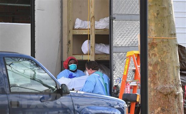 Nhân viên y tế chuyển thi thể bệnh nhân COVID-19 từ một nhà xác dã chiến tới Trung tâm y tế Do thái Kingsbrook ở Brooklyn, New York, Mỹ, ngày 8/4/2020. (Ảnh: AFP/TTXVN)