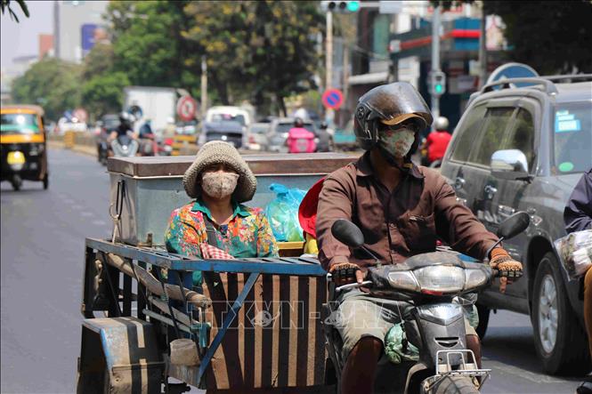 Người dân đeo khẩu trang phòng lây nhiễm COVID-19 trên một đường phố ở Phnom Penh, Campuchia, ngày 25/3/2020. Ảnh: THX/TTXVN