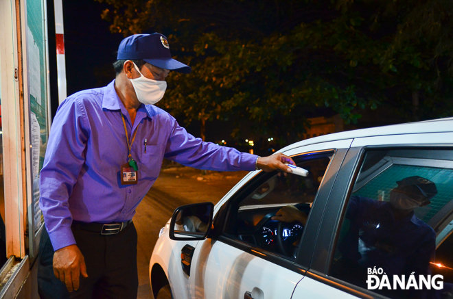 Car and truck drivers have their temperature taken at the entrance road