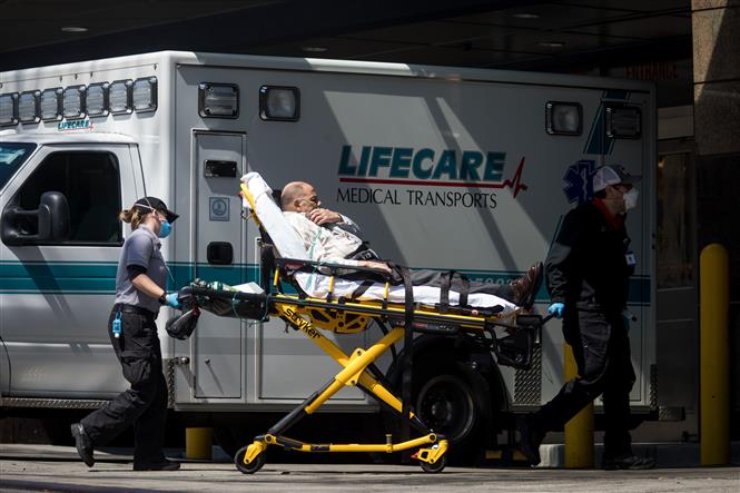 Nhân viên y tế chuyển bệnh nhân mắc Covid-19 từ xe cứu thương vào một bệnh viện ở New York, Mỹ ngày 11/4/2020. Ảnh: THX/TTXVN