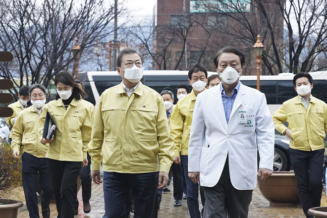 Tổng thống Hàn Quốc Moon Jae-in (trái, hàng trước) cùng các quan chức chính phủ đã nỗ lực kiểm soát Covid-19. 				               Ảnh: Bloomberg