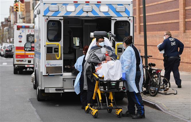 Nhân viên y tế chuyển bệnh nhân nhiễm COVID-19 tới trung tâm y tế Wyckoff Heights tại New York, Mỹ ngày 7/4/2020. Ảnh: AFP/ TTXVN