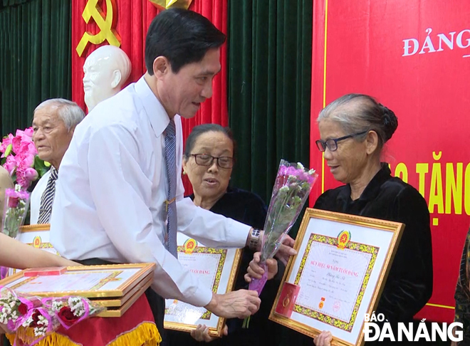 Bà Phùng Thị Nữ (bìa phải) nhận Huy hiệu 50 năm tuổi Đảng. Ảnh: THANH LÀI