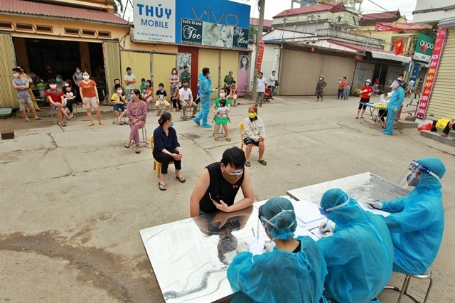 Residents in Ha Loi Village wait to be tested for Covid-19