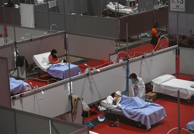Nhân viên y tế điều trị cho bệnh nhân Covid-19 tại bệnh viện dã chiến ở Madrid, Tây Ban Nha. Ảnh: AFP- TTXVN