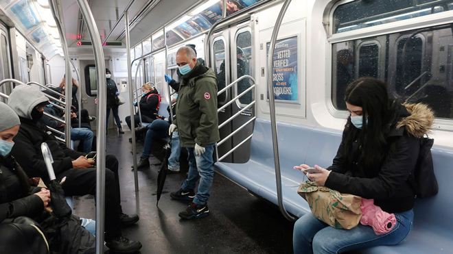 Người dân mang khẩu trang khi đi tàu điện ngầm ở  New York. 				Ảnh: AP