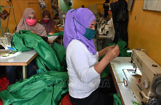 Công nhân may đồ bảo hộ y tế cá nhân và khẩu trang phòng lây nhiễm Covid-19 tại Tangerang, Indonesia, ngày 7-4. Ảnh: AFP/TTXVN