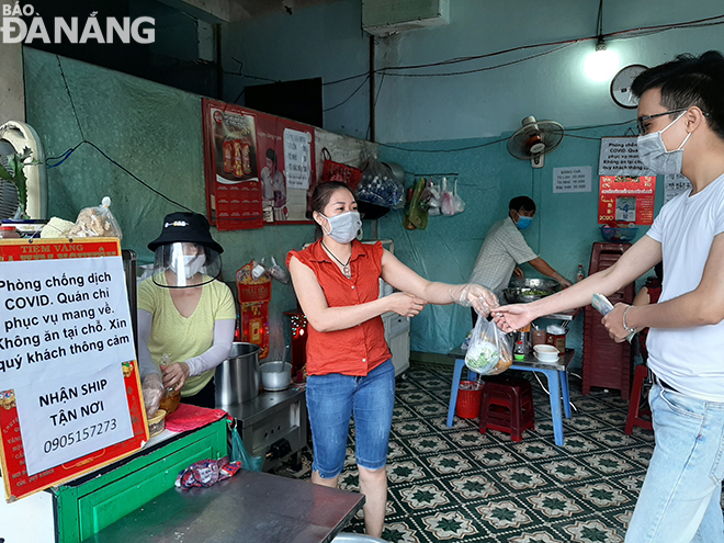 Both owner and employees of an eatery in Cam Le District wearing face masks 