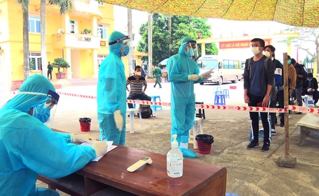 Vietnamese citizens returning from the UK queue up to wait for their turn to make health declaration at a quarantine centre in Hung Yen province on April 15 (Photo: VNA)