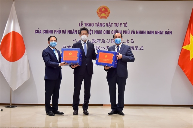 Vietnamese deputy foreign minister Bùi Thanh Sơn and Chairman of Government Office Mai Tiến Dũng handover the gifts of medical supplies to Japanese Deputy Ambassador to Việt Nam Asazuma Shinichi. 