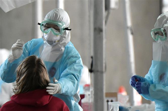  Nhân viên y tế lây mẫu xét nghiệm COVID-19 cho hành khách nước ngoài tại sân bay quốc tế ở Seoul, Hàn Quốc, ngày 1/4/2020. Ảnh: AFP/TTXVN