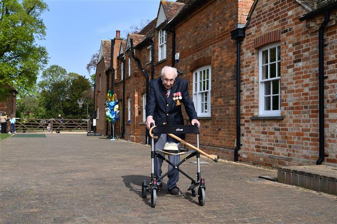  Cụ ông Tom Moore, 99 tuổi, nỗ lực thực hiện dự án đi bộ 100 vòng trong khu vườn ở Marston Moretaine, phía bắc London, ngày 16/4/2020 nhằm gây quỹ hỗ trợ đội ngũ y tế Anh đối phó dịch COVID-19. Ảnh: TTXVN phát