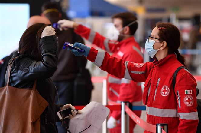 Thành viên hội Chữ Thập đỏ Italy kiểm tra thân nhiệt của hành khách tại nhà ga tàu hỏa Termini ở Rome, ngày 9/4/2020 trong bối cảnh dịch COVID-19 lan rộng. Ảnh: THX/TTXVN