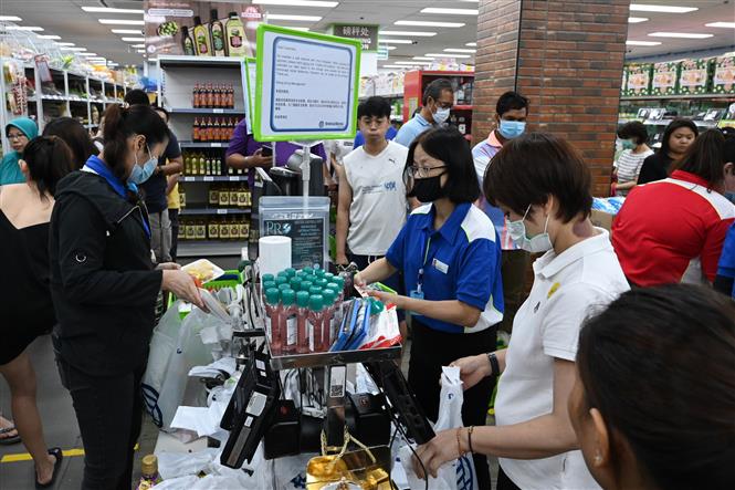 Người dân đeo khẩu trang phòng lây nhiễm COVID-19 khi mua hàng tại siêu thị ở Singapore ngày 3/4/2020. Ảnh: AFP/ TTXVN